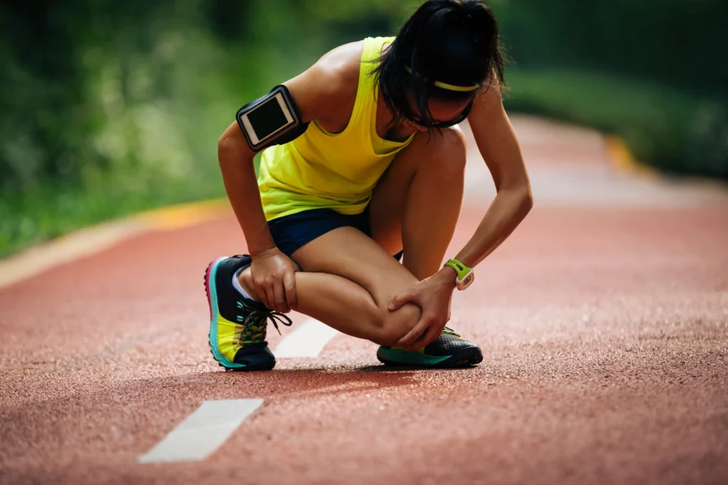 5 Essential Treatments For Sports Injuries Manchester Athletes Face: Your Complete Guide To Sports Injury First Aid 3 sports injury running athlete holding her injured ankle
