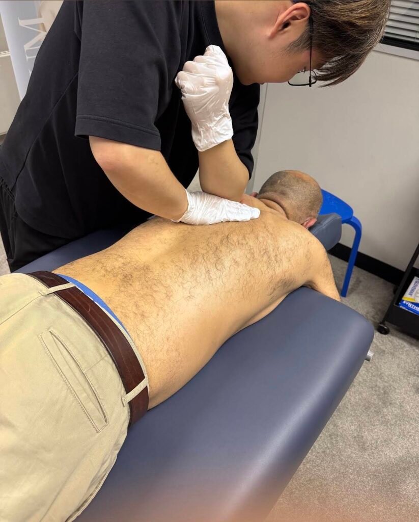 Professional therapist using elbow for deep tissue sports massage Manchester session at Hekas clinic