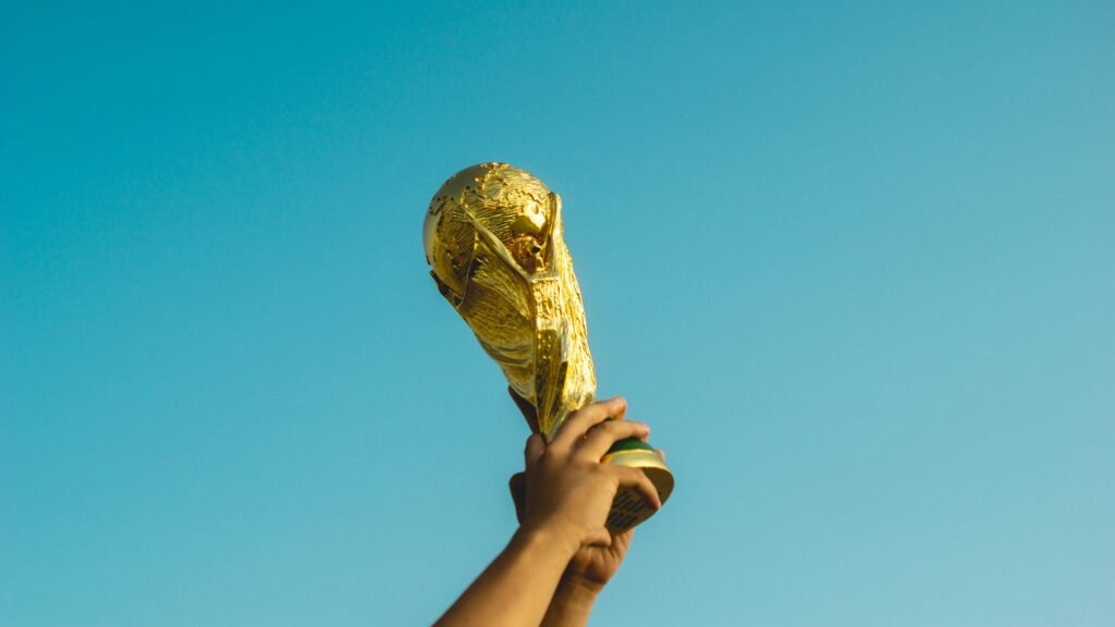 Congratulations Spain! What World Cup Heroes Can Teach Us About Off-Season Recovery & Injury Prevention 2 Spain fans celebrating World Cup victory with trophy raised at stadium