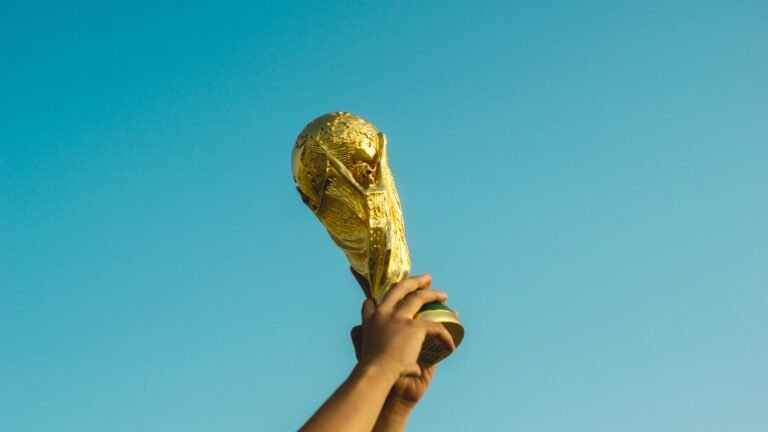 Congratulations Spain! What World Cup Heroes Can Teach Us About Off-Season Recovery & Injury Prevention 3 Spain fans celebrating World Cup victory with trophy raised at stadium