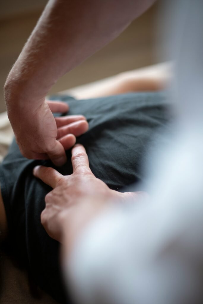 Sports therapist treating lower back tightness and muscle repair for a patient in Manchester clinic
