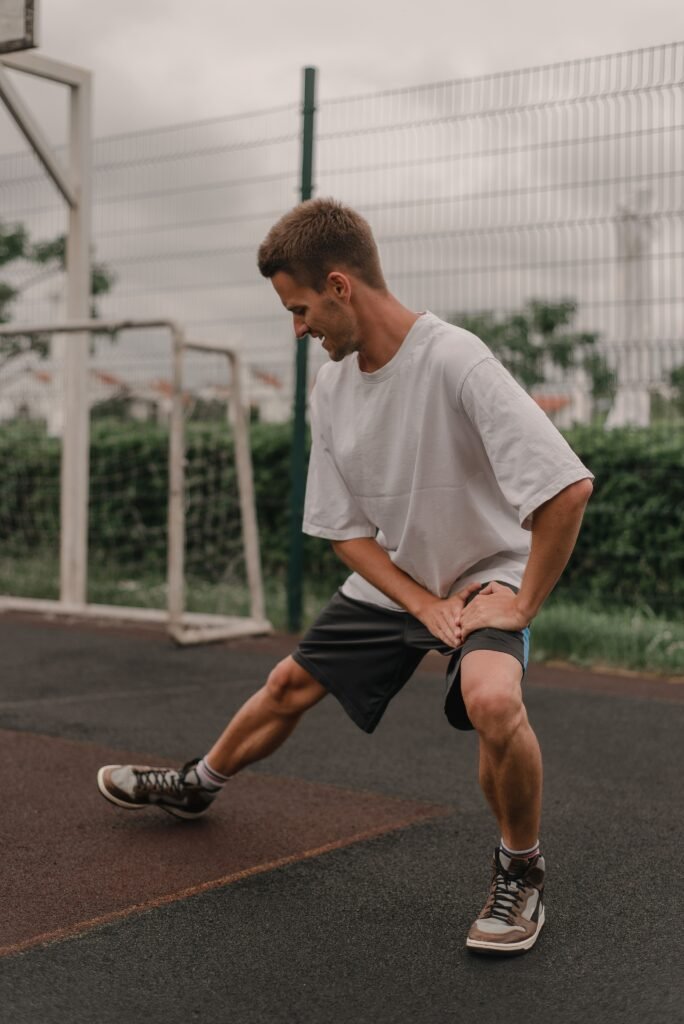 How Do High-Mileage Runners Use Percussion Therapy for Hip Flexor Tightness? 3 Runner stretching the hip flexor and quad after a run